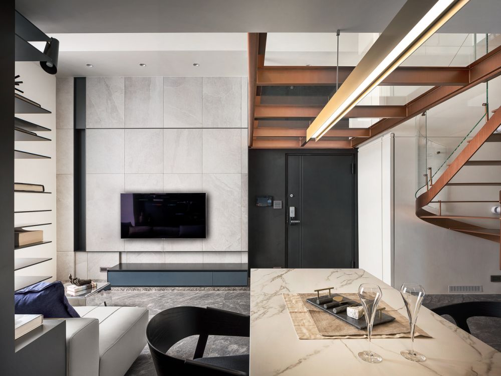 The kitchen island is placed perpendicular to the living room sofa, serving as a visual demarcator between the two areas