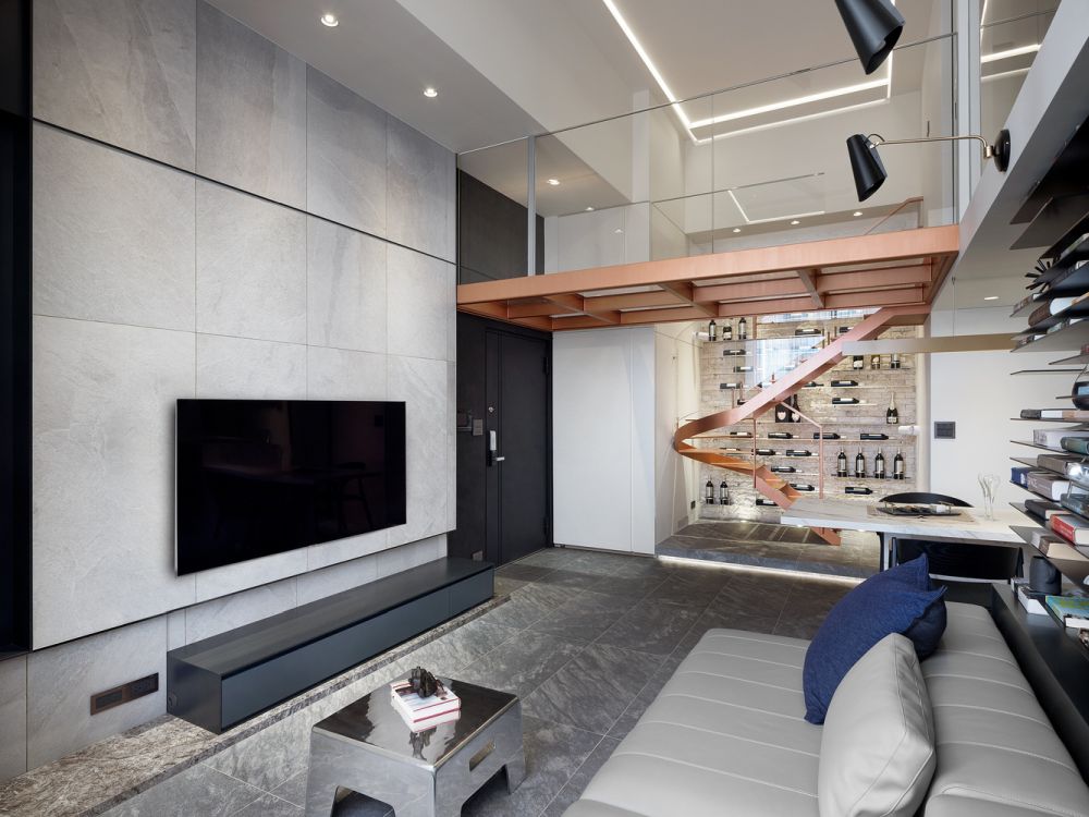 The sofa faces a wall-mounted TV with a low and minimalist console beneath it
