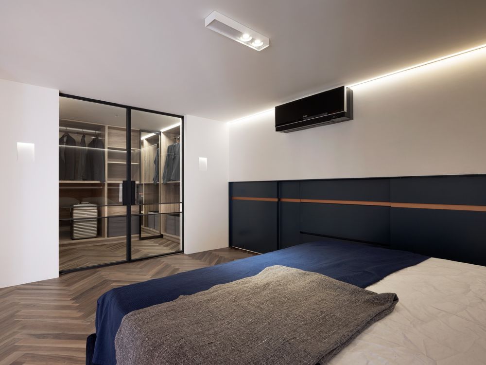 The bedroom has a spacious walk-in closet with glass doors and warm lighting