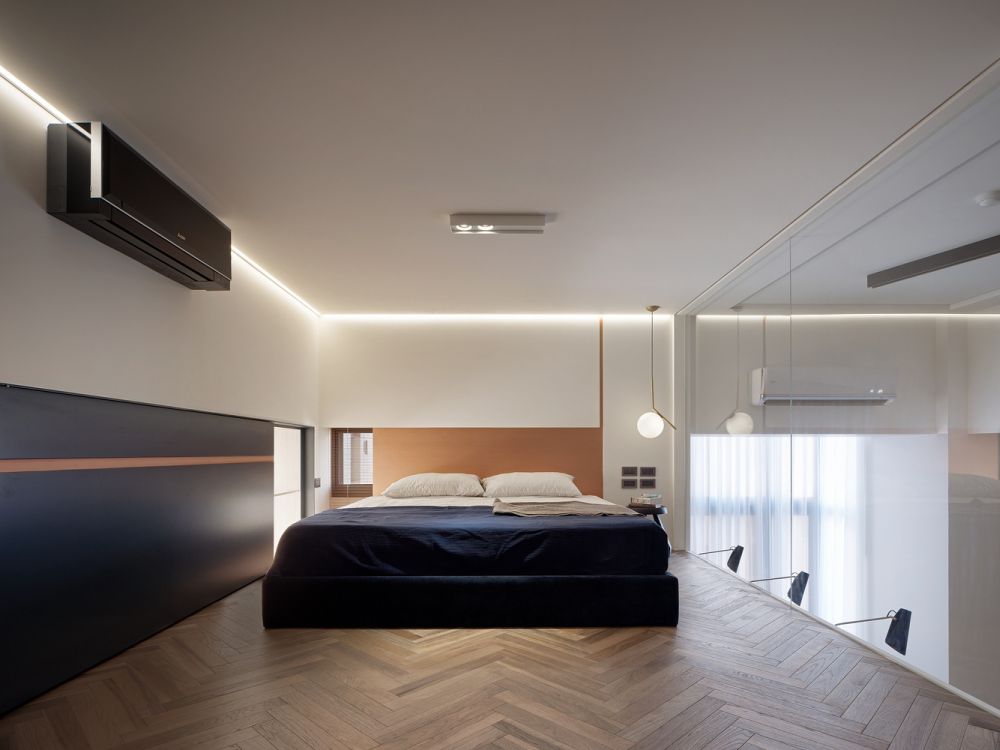 Upstairs the bedroom has herringbone wooden flooring, LED strips marking the ceiling and a glass wall