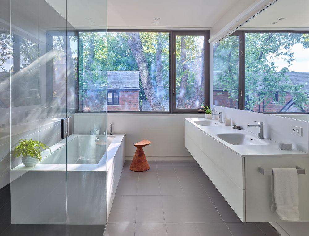 The bathroom is filled with natural light too and features large windows and glass partitions which take advantage of this