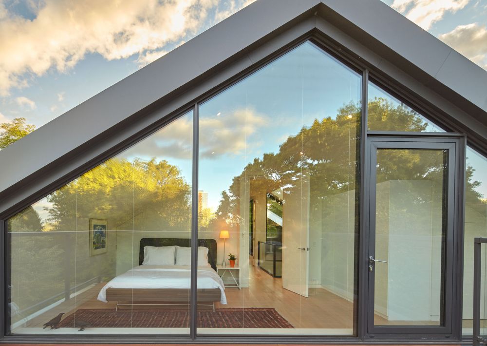The master bedroom and the deck are separated by full-height glass panels which ensure a seamless connection