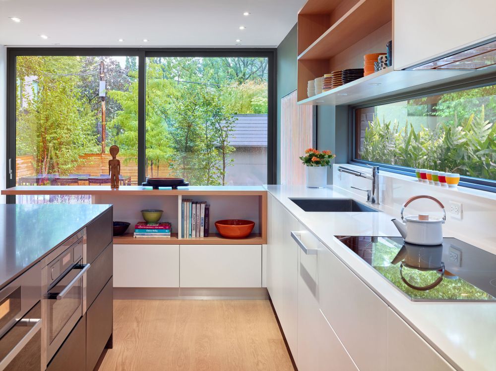 The kitchen is L-shaped, with windows on both sides and a practical island with built-in appliances