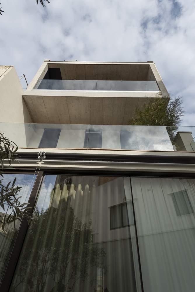 The glazed facade and glass railings give the house a contemporary appearance
