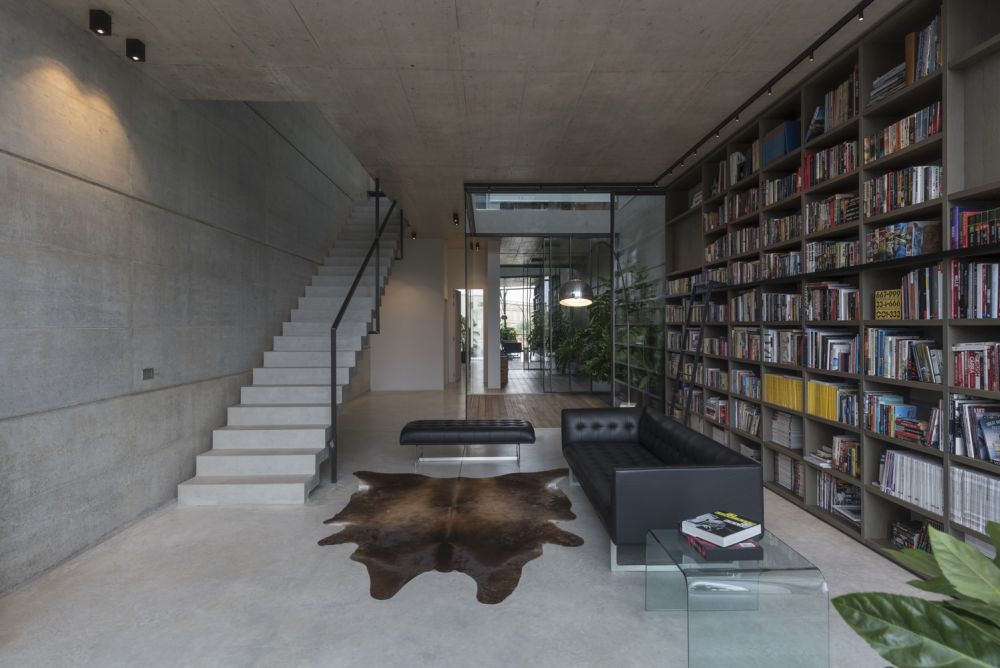 A large bookcase stretches over the living room wall creating an inviting decor and adding color to the space