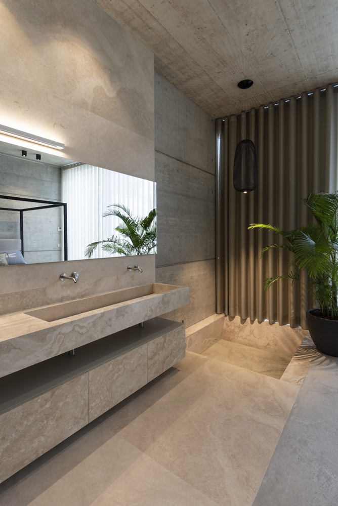 The master bathroom is designed with warm, earthy colors and has pleasant accent lighting throughout