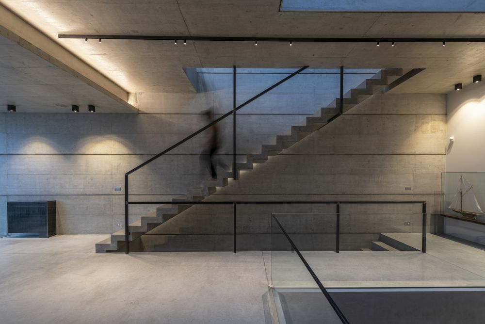 The floors are connected via a simple concrete staircase which also acts as a separator between various zones