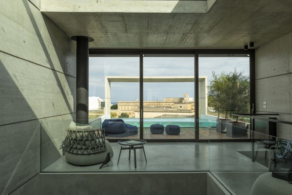 The rooftop swimming pool is framed by an open wood deck with comfortable outdoor furniture