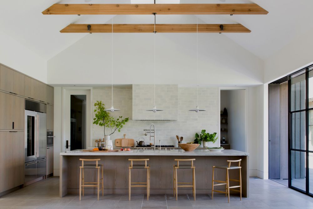 The large open kitchen has direct access outdoors and features a marble-top island with bar seating