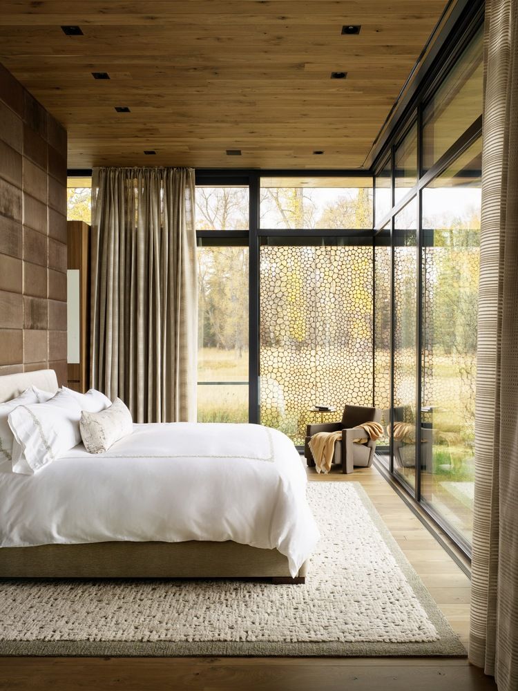 Full-height glass walls and windows open up the spaces towards the serene surroundings