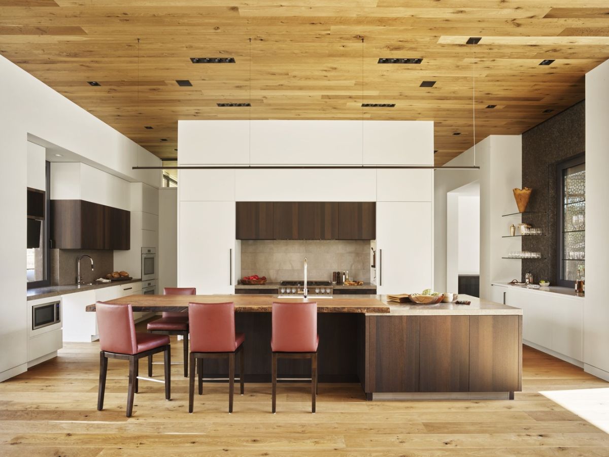 The kitchen, dining area and the living share an open plan space with wooden floors and matching ceilings