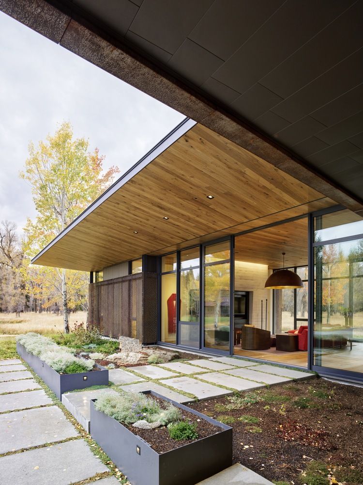 In the context of the L-shaped floor plan, the garage occupies the smaller side and the social areas the other
