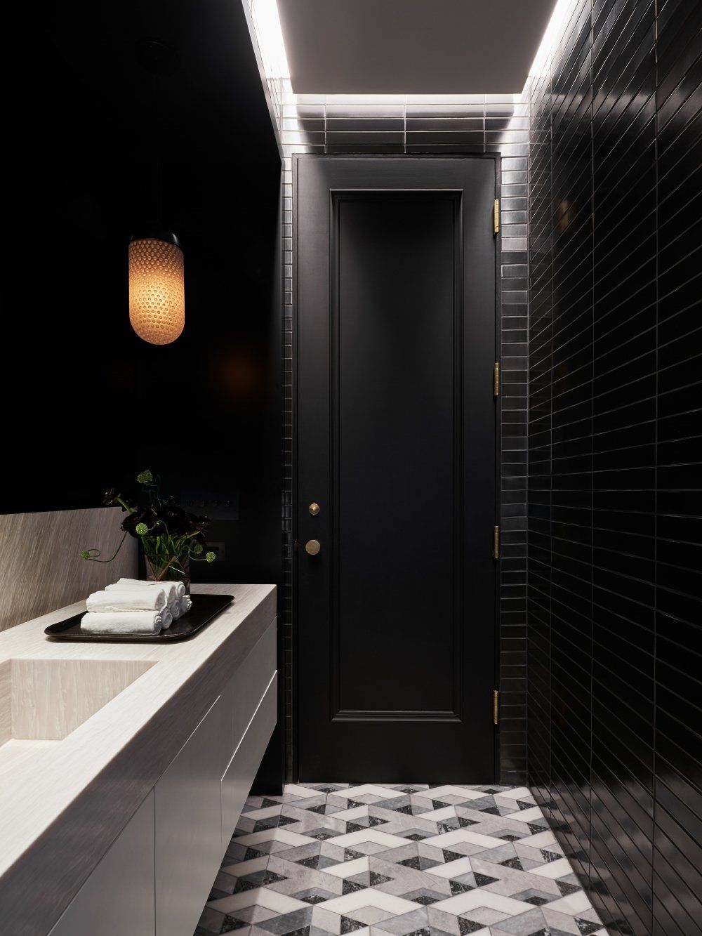 The closet was converted into a powder room with geometric floor tiles and black walls