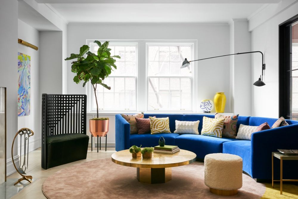 The new living room design is much brighter and has a custom curved sofa as a centerpiece