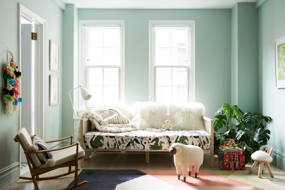 The mint green wall color, casual daybed and rocking chair combo give this bedroom a much fresher vibe