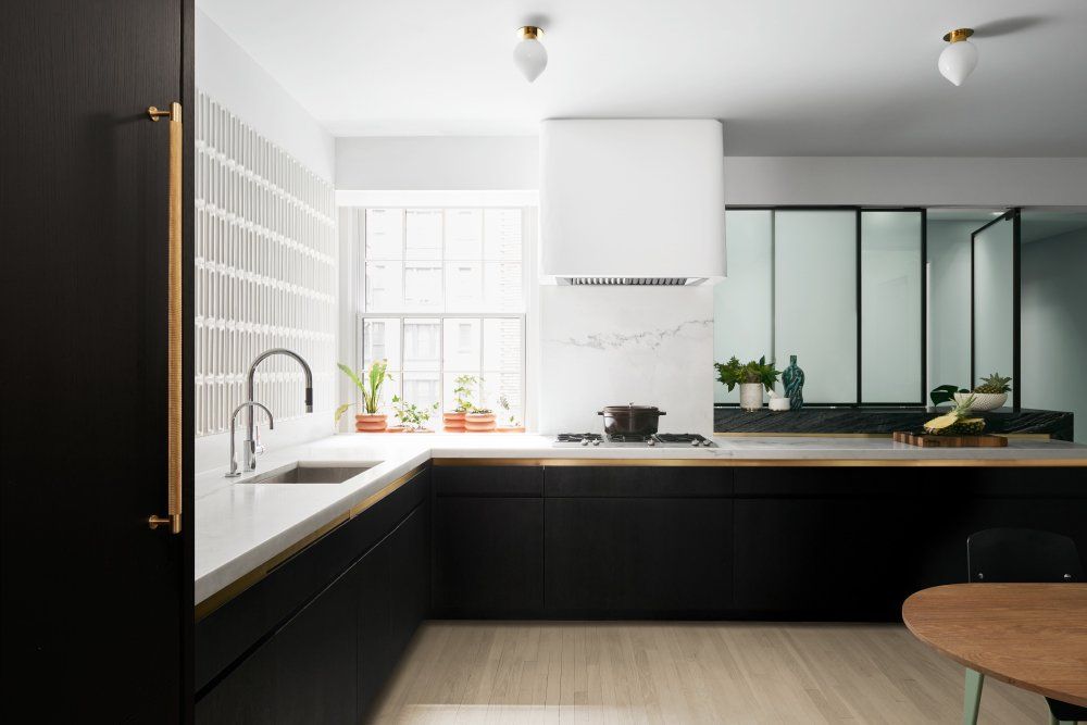 The reimagined kitchen has no upper cabinetry and crisp white walls which better reflect the light