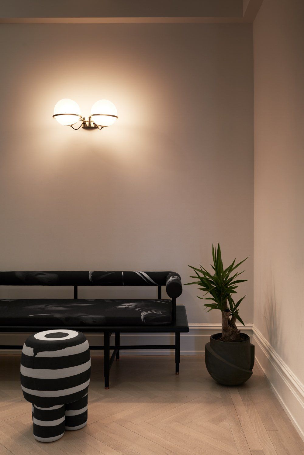 A lighter floor color, muted pink walls and black and white furniture give the entryway a glamorous look