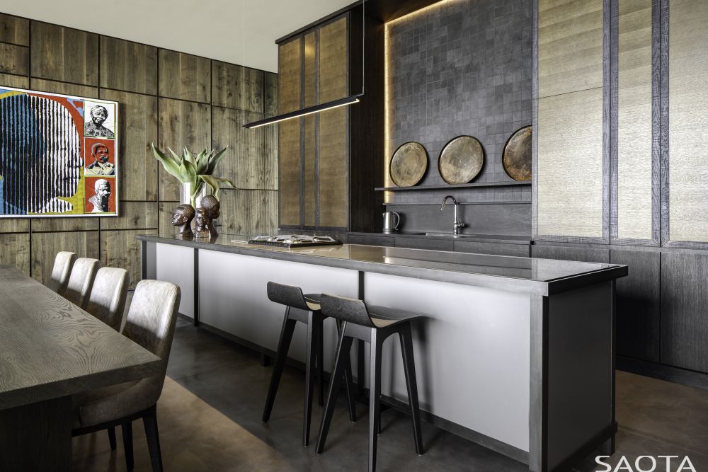 The kitchen is seamlessly integrated into this open floor plan, featuring a large island and stylish lighting fixtures