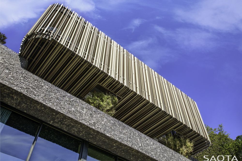 The box-like volume which hovers over the ground floor allows trees to grow inside it