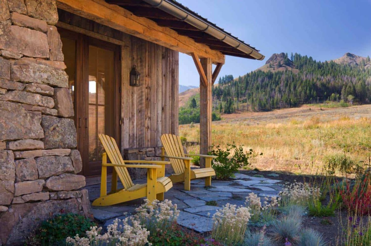 Two classic Adirondack chairs sit just outside the entrance, extending the living areas outside