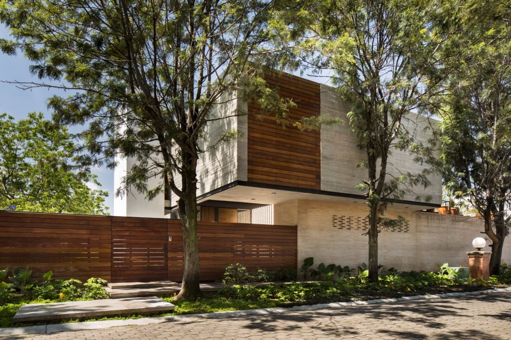 The wooden shutters and the matching privacy fence balance out the concrete volumes