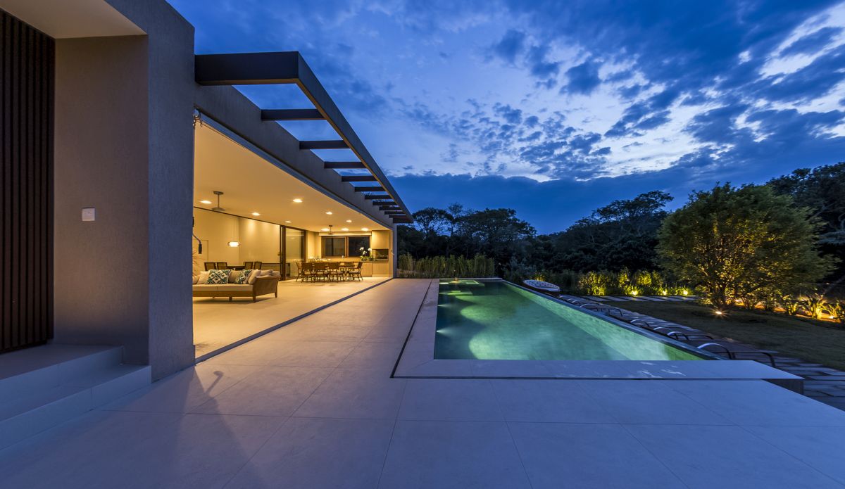 The living area opens up towards the poolside terrace, having the garden and the forest as a backdrop