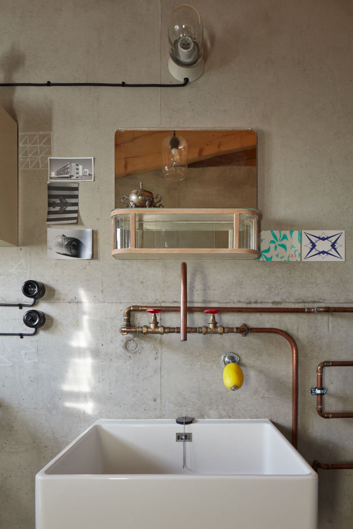 The en-suite bathroom has bare walls and exposed pipes which double as decorative elements