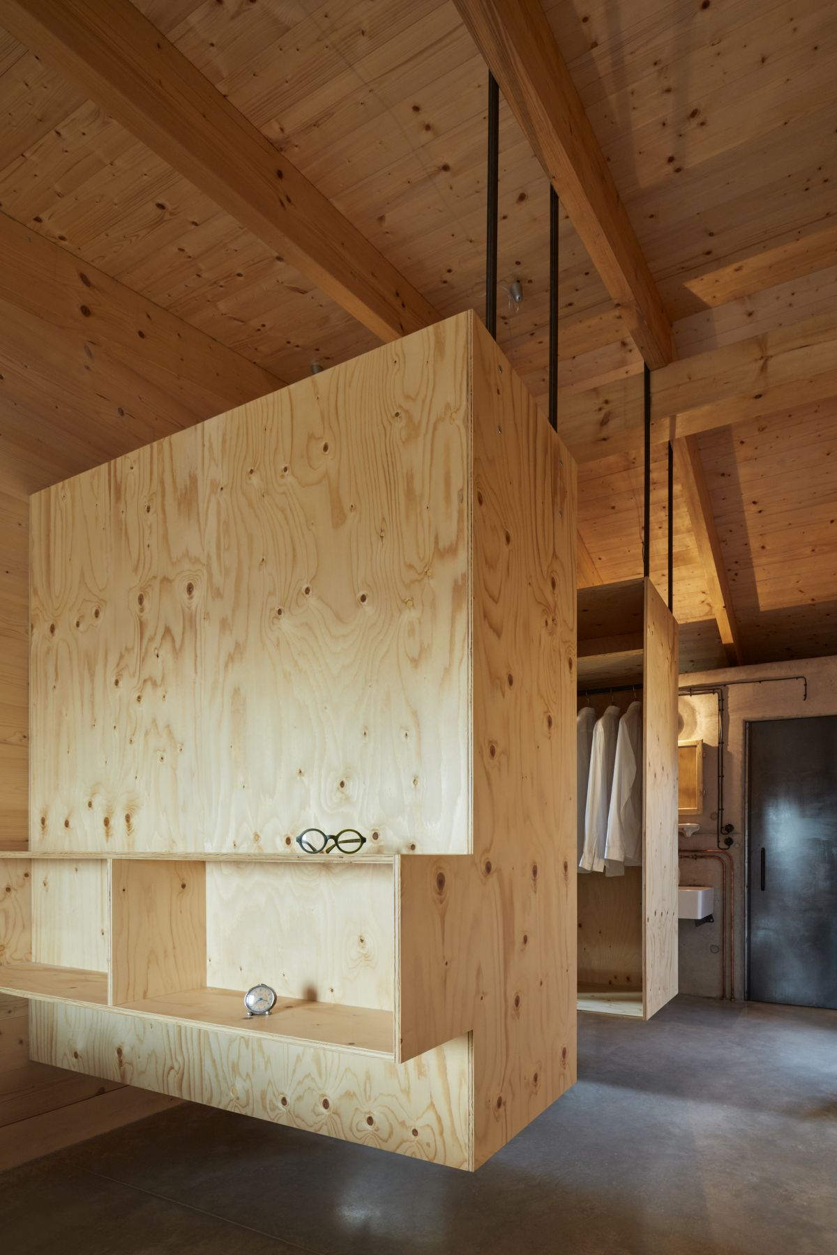 The master bedroom features wardrobe units hanging from the ceiling which saves floor space and creates an airy look