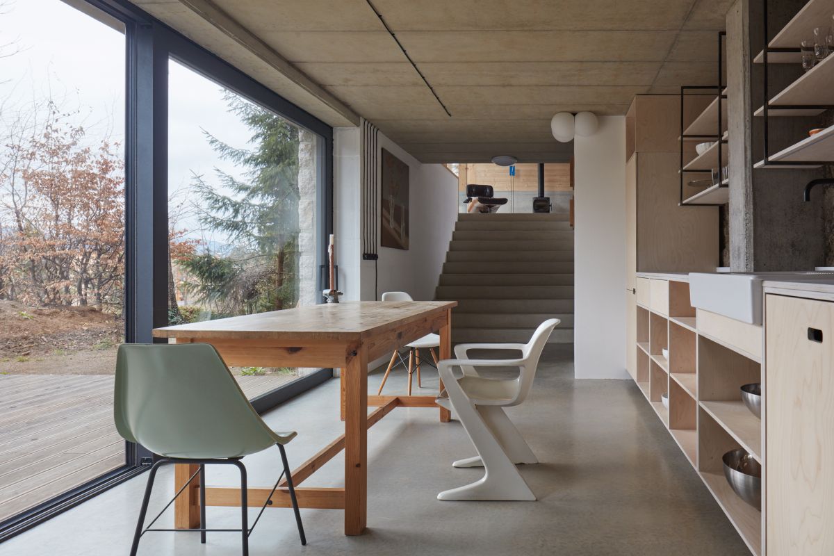 A set of wide concrete stairs connect the kitchen and dining area to the lounge space