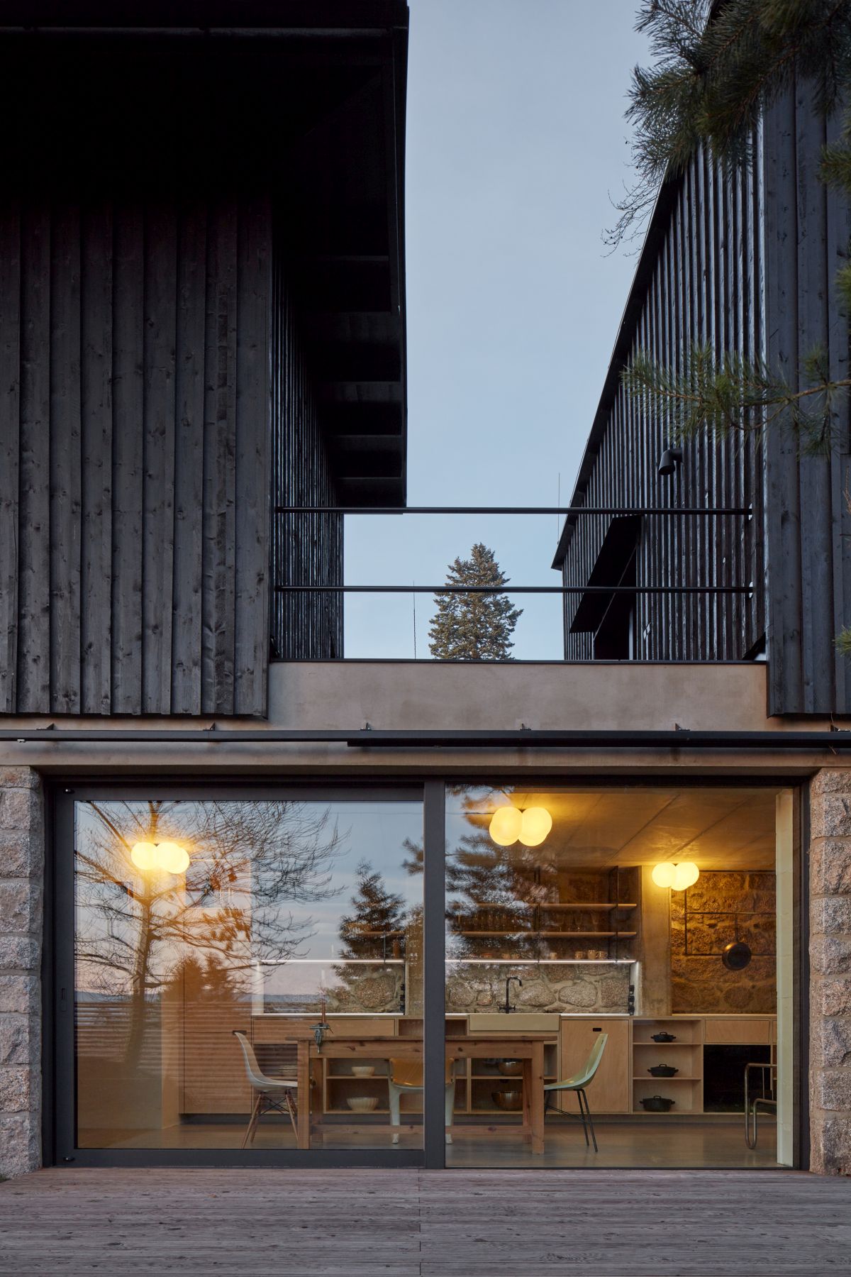 the new additions are placed on top of the stone volume and are clad in timber