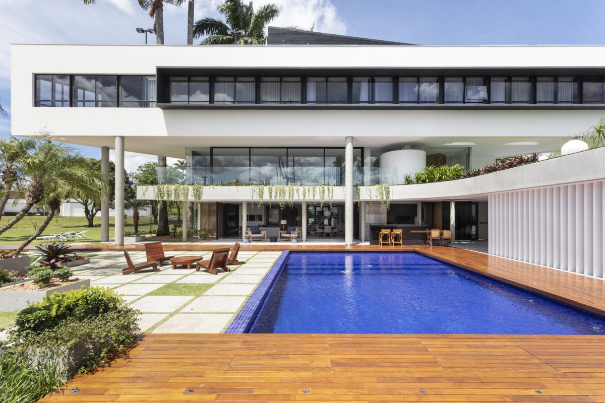 A wooden deck frames the pool and strengthens the bond between the indoor and the outdoor spaces