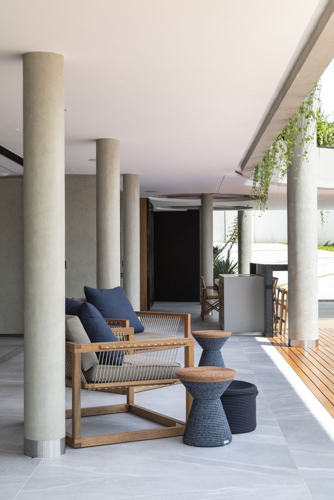 A series of round structural columns are spread throughout the ground floor and extend outside