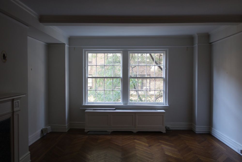 The living room originally had darker-colored herringbone flooring and felt quite small because of that