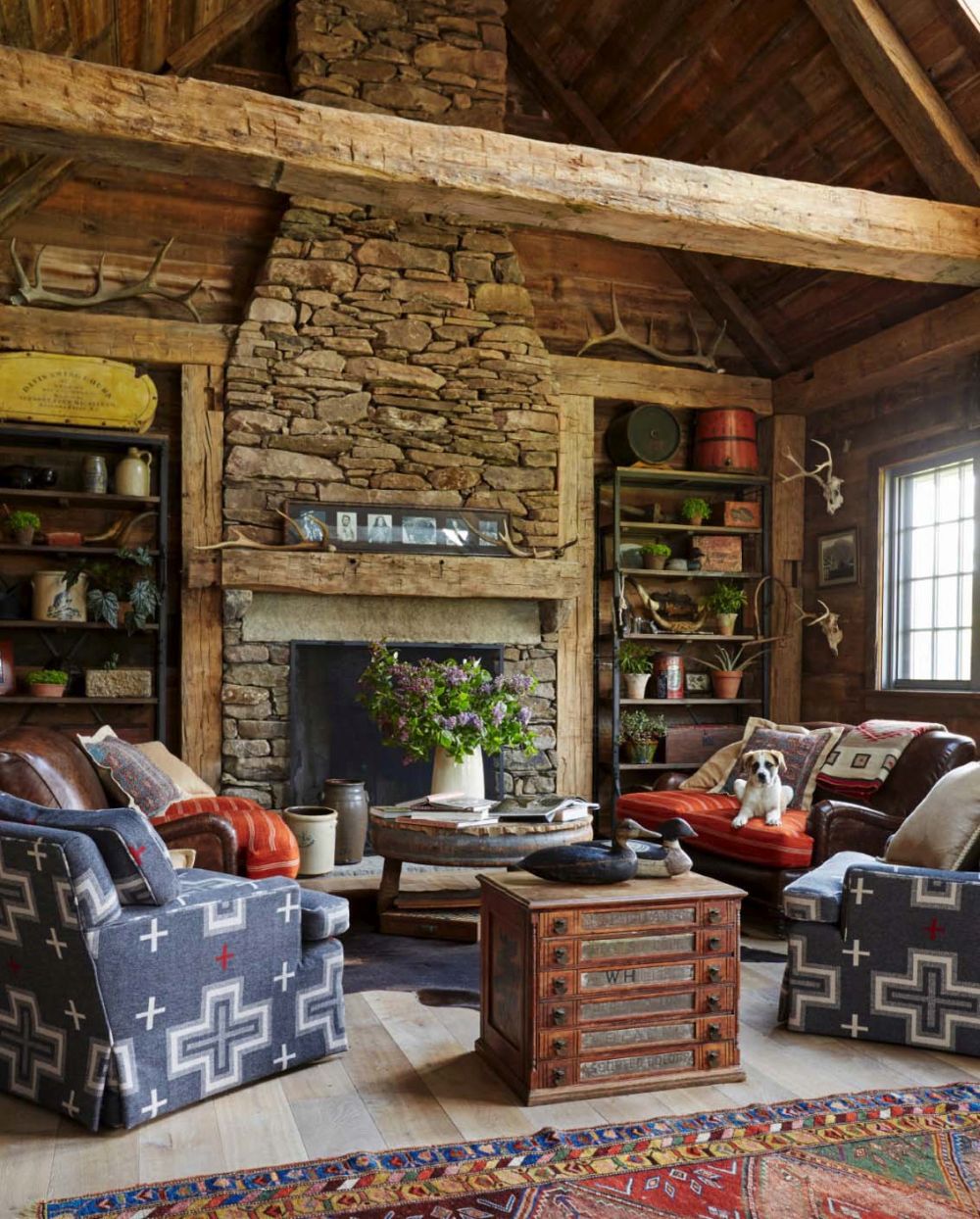 The living room features a cozy seating area arranged in front of a large stone-clad fireplace