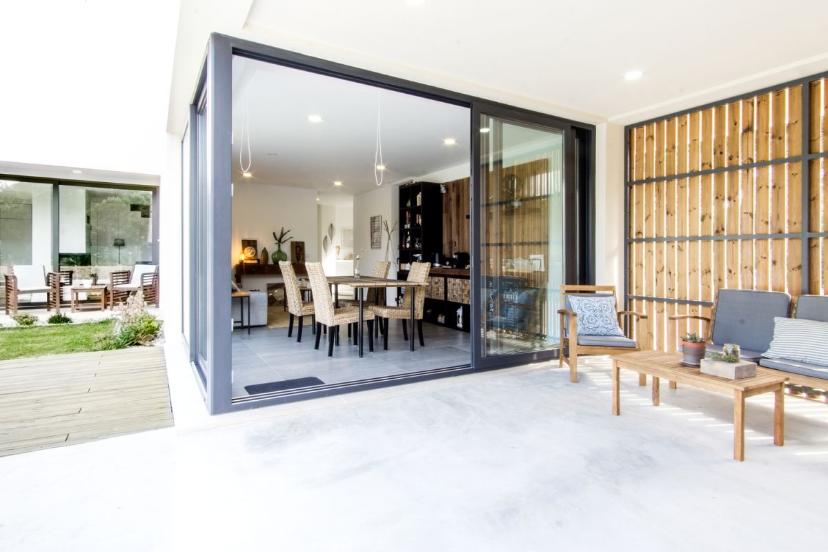 The living spaces have sliding glass doors which connect them to the deck and garden