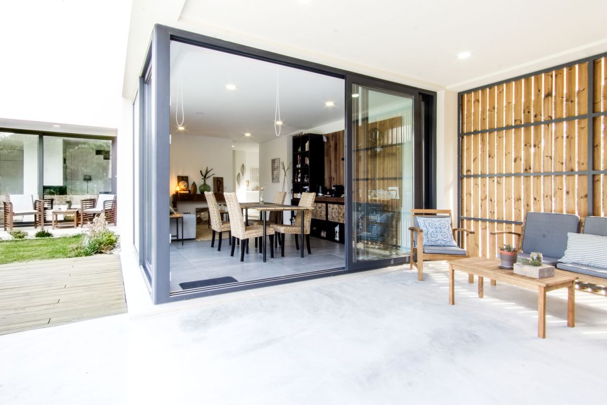 The living spaces have sliding glass doors which connect them to the deck and garden