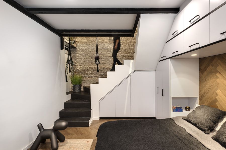 The basement area functions as a night zone, with a double bed as a central piece and custom furniture all around it