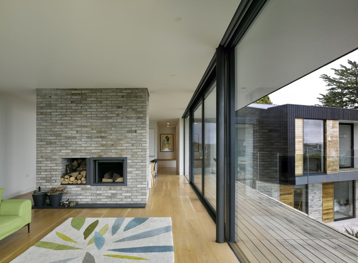 The living room has a fireplace which doubles as a space divider, separating the lounge area from the rest of the floor plan