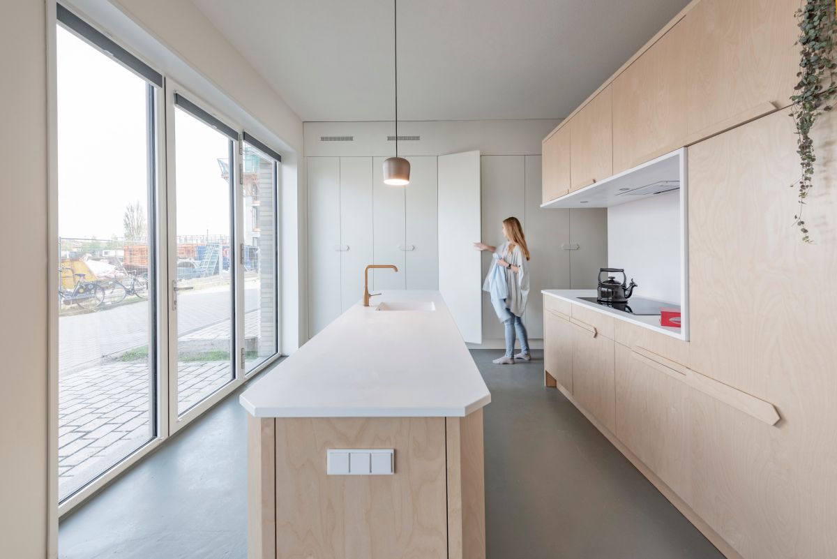 A custom built storage unit covers almost the entire wall, with a white front that lets it blend in