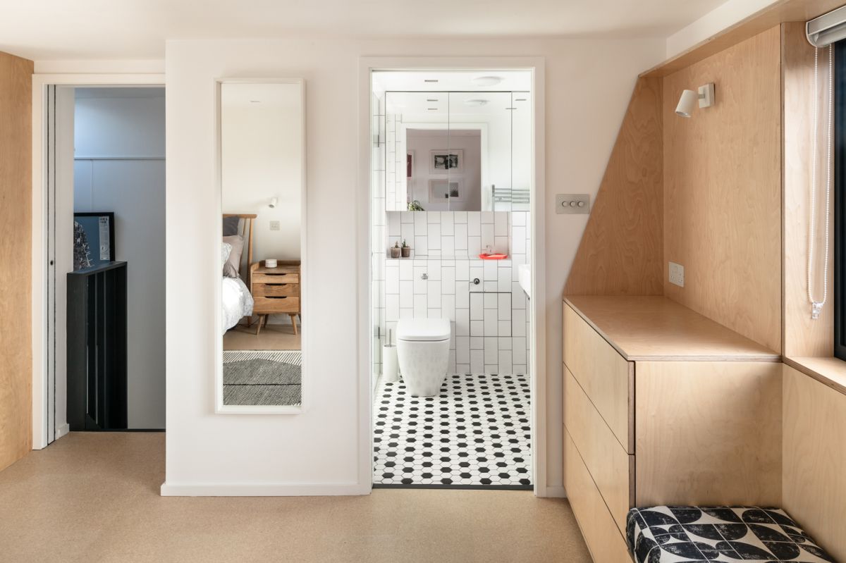 The en-suite bathroom plays with the classic black and white combo and manages to look spacious in spite of its size