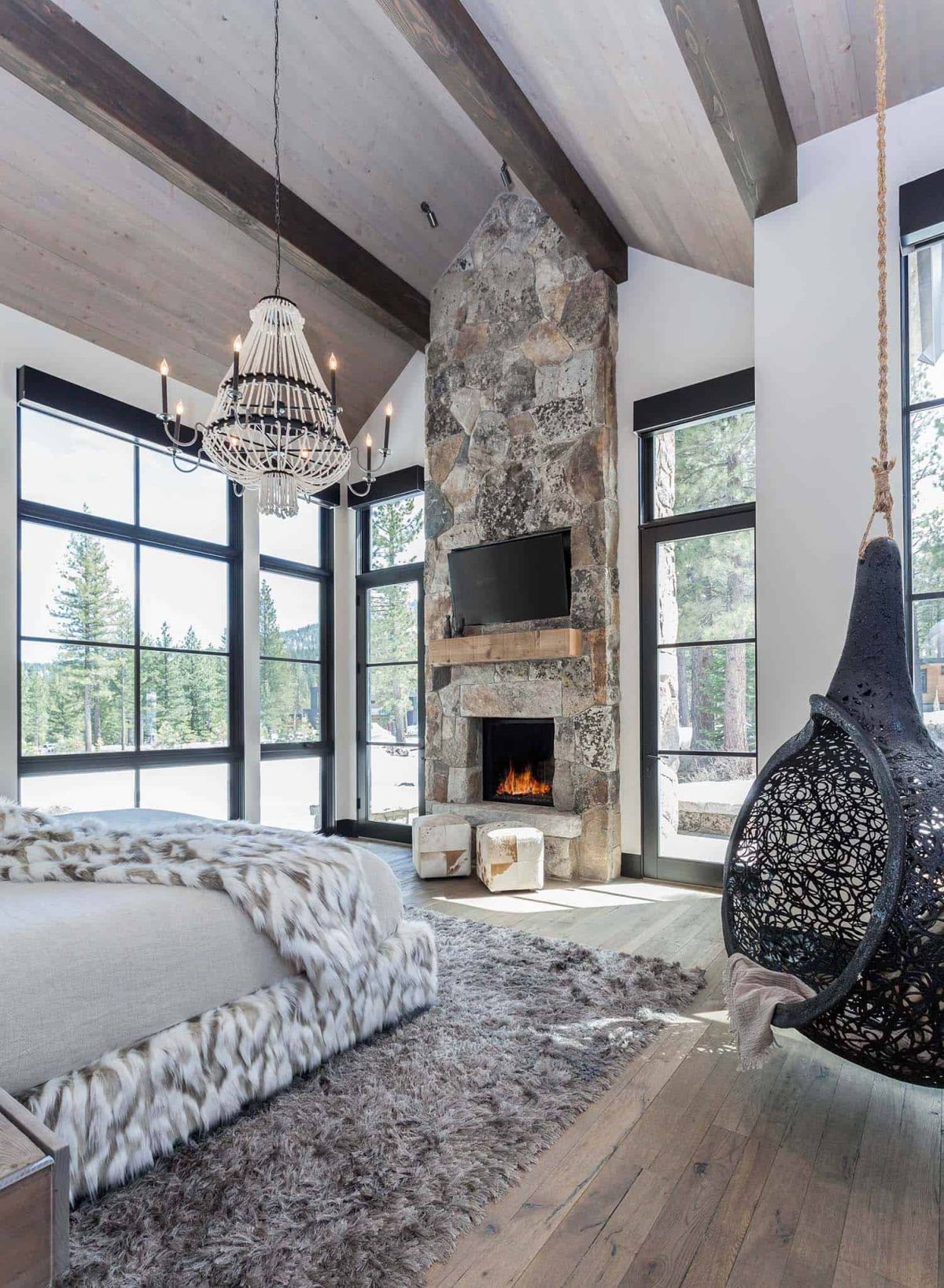 The master bedroom has its own stone fireplace which emphasizes the height of the space in a very nice way