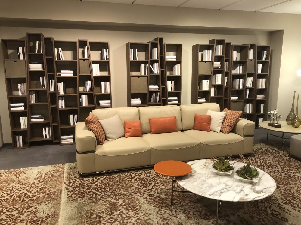 These wavy bookshelves cover up the entire back wall and that gives the living room a somewhat formal look