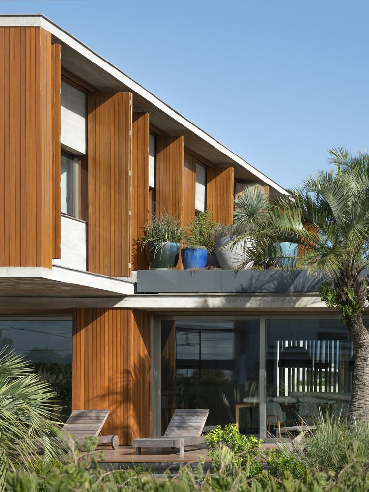 The cantilevered top floor forms a protective roof over the ground floor porch area