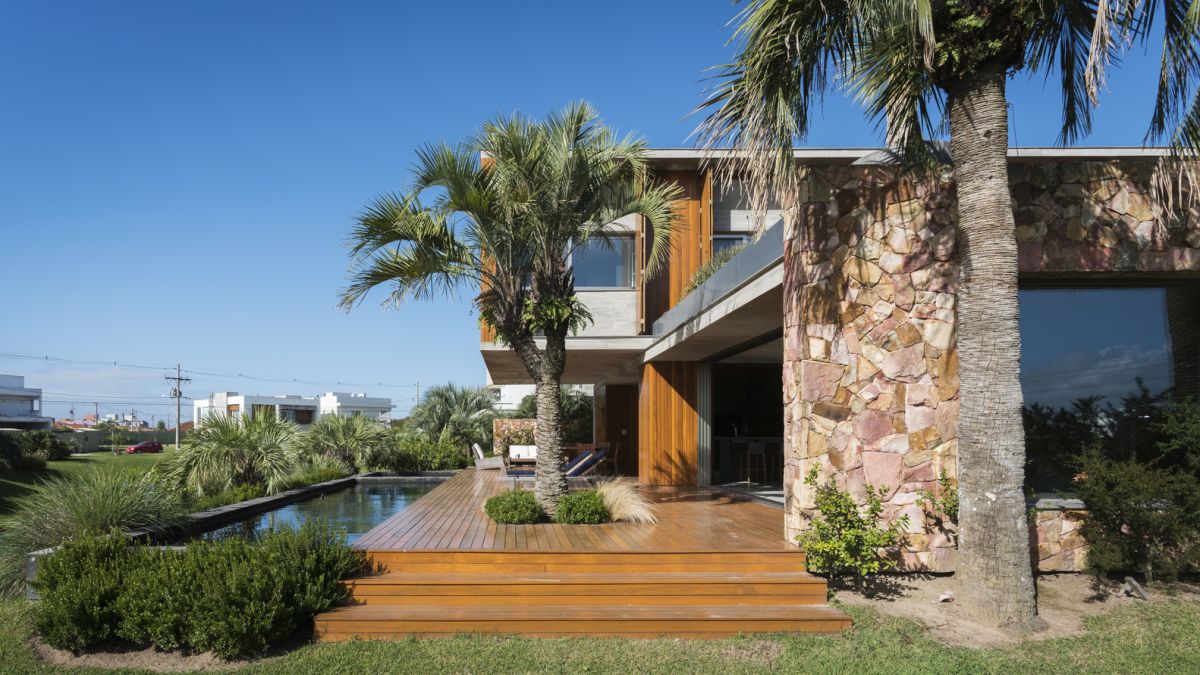 The living area can be seamlessly opened up onto the wooden deck and poolside area