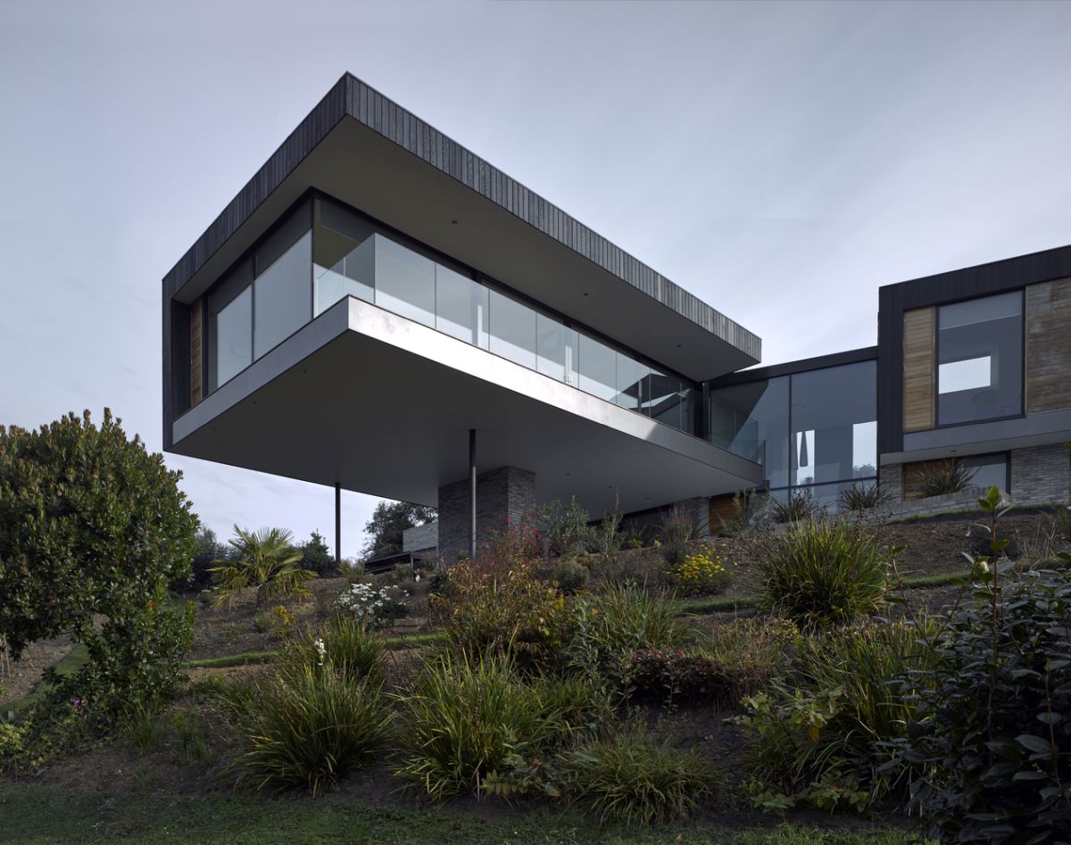 The cantilevered section of the house forms a protective roof over ground floor deck