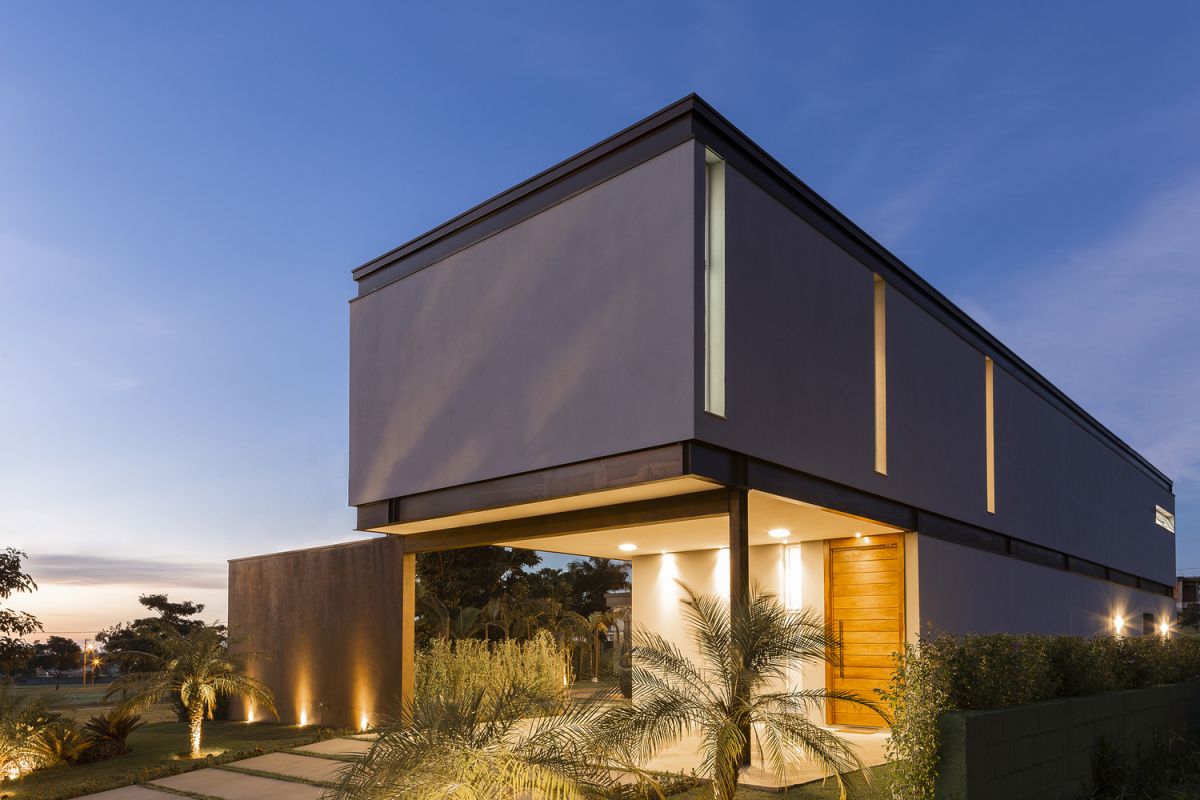 The tall wooden doors contrast with the metal frame and concrete exterior