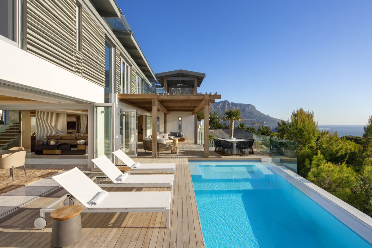 The house is framed by stunning views of the mountain range and the valley and forests around it