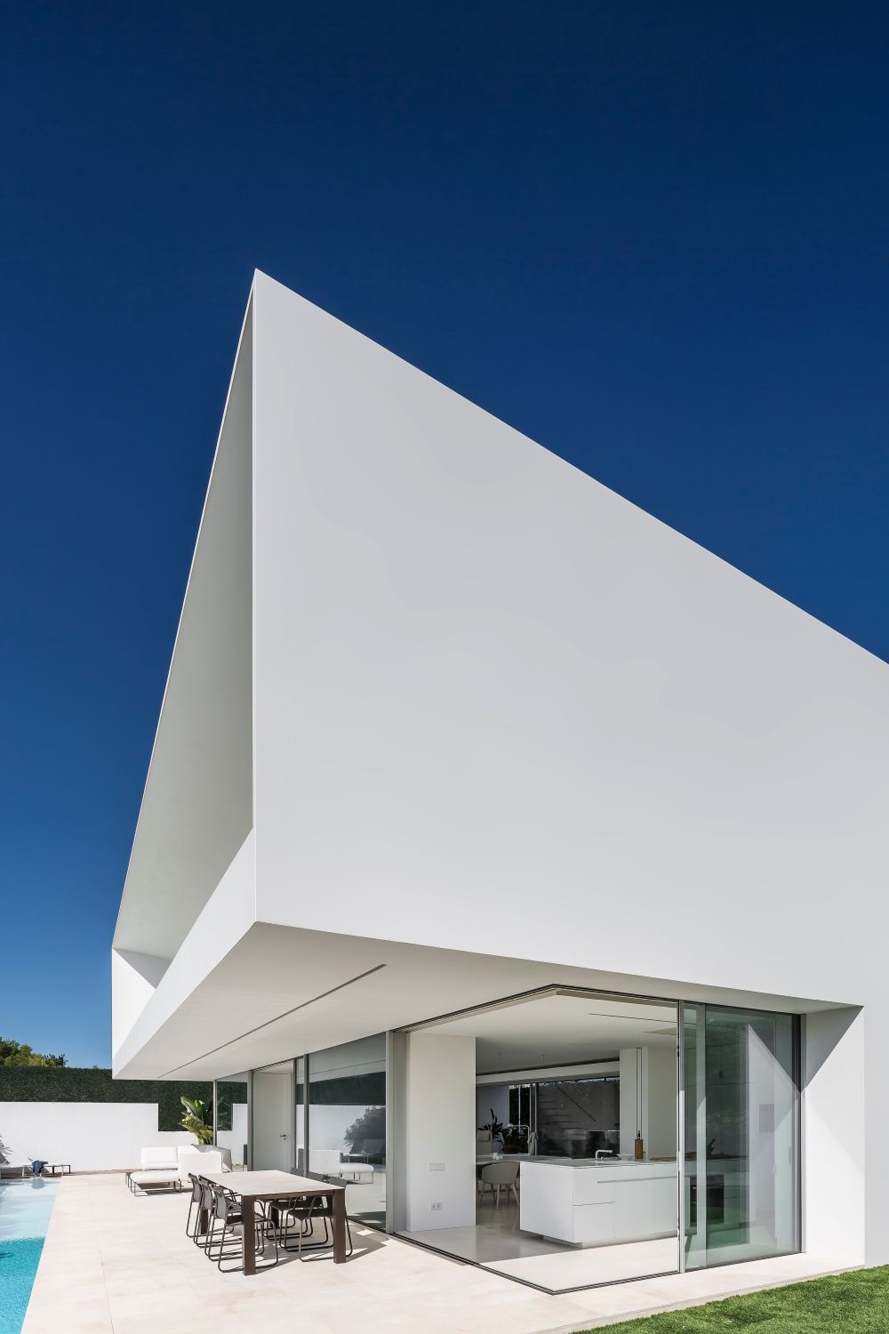  The house has a very clean and minimalistic aesthetic, featuring an all white exterior with large glazed surfaces
