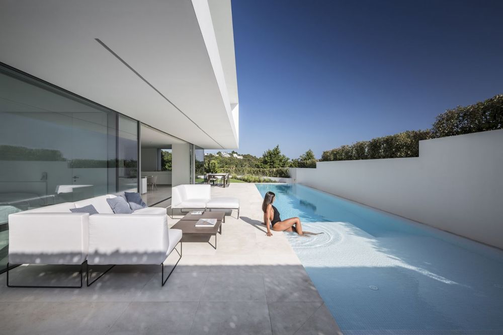 The water in the pool is level with the deck which enhances the continuity between all the different spaces