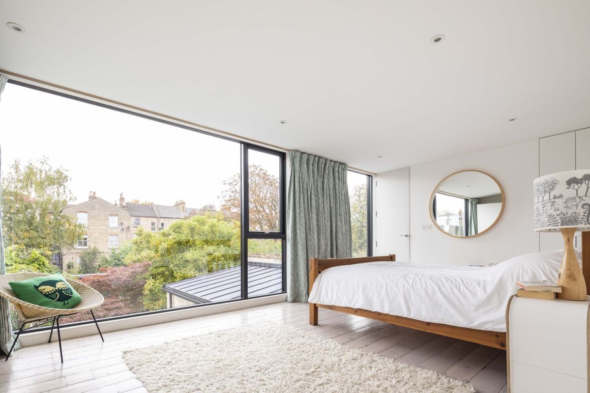 The upstairs bedroom has a huge panorama window with a great view of the garden